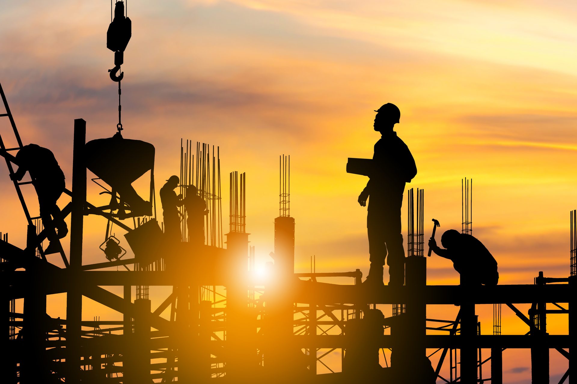 Silhouetten von Ingenieur und Bauarbeitern auf einer Baustelle bei Sonnenuntergang – Vollwerk GmbH Wuppertal